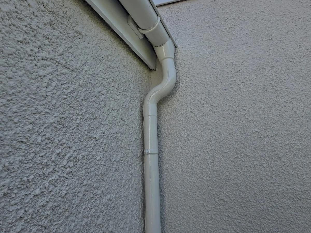 Gouttière et descente d'eau pluviale en zinc posées le long d'un mur